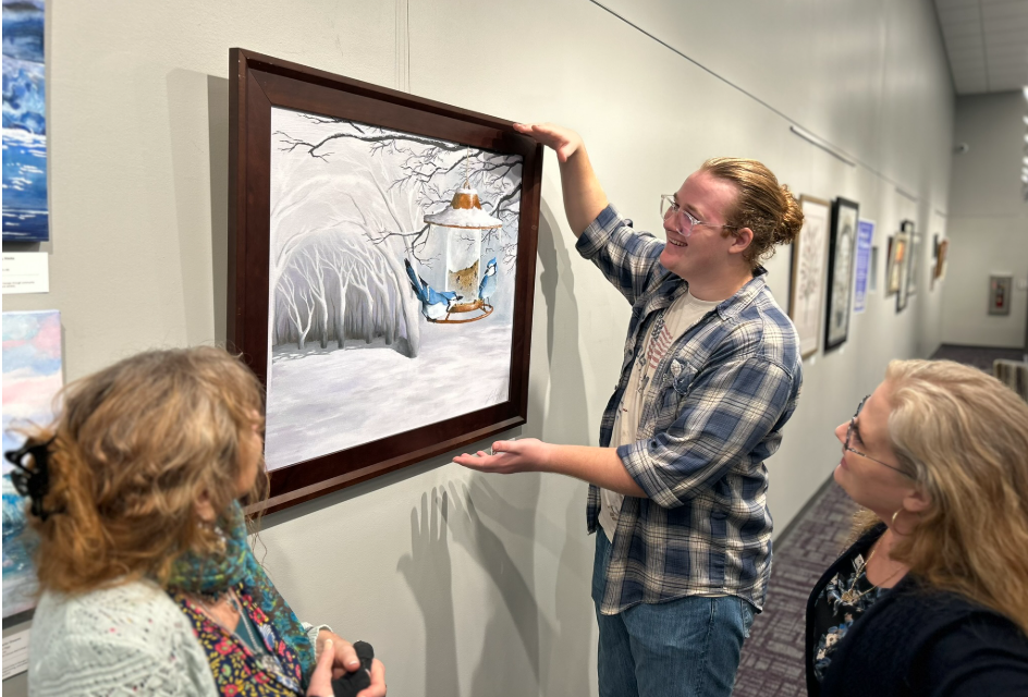 Artist Trenon Augard hanging their work at Buckhead Library